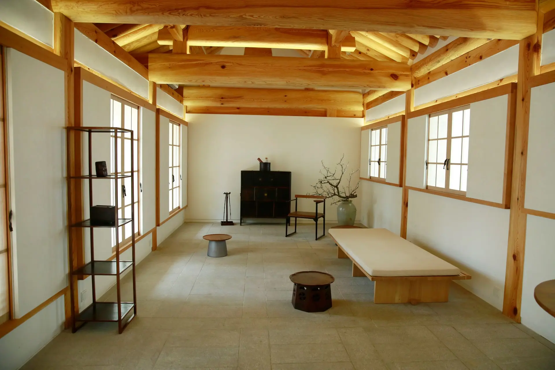 Room with exposed timber posts and ceiling beams and wood trimmed windows